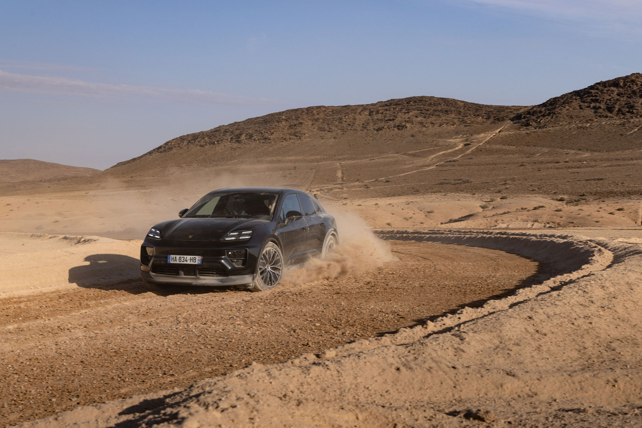 Porsche Macan Électrique en action dans le désert d’Agafay Porsche Macan électrique prenant un virage dans le désert d’Agafay