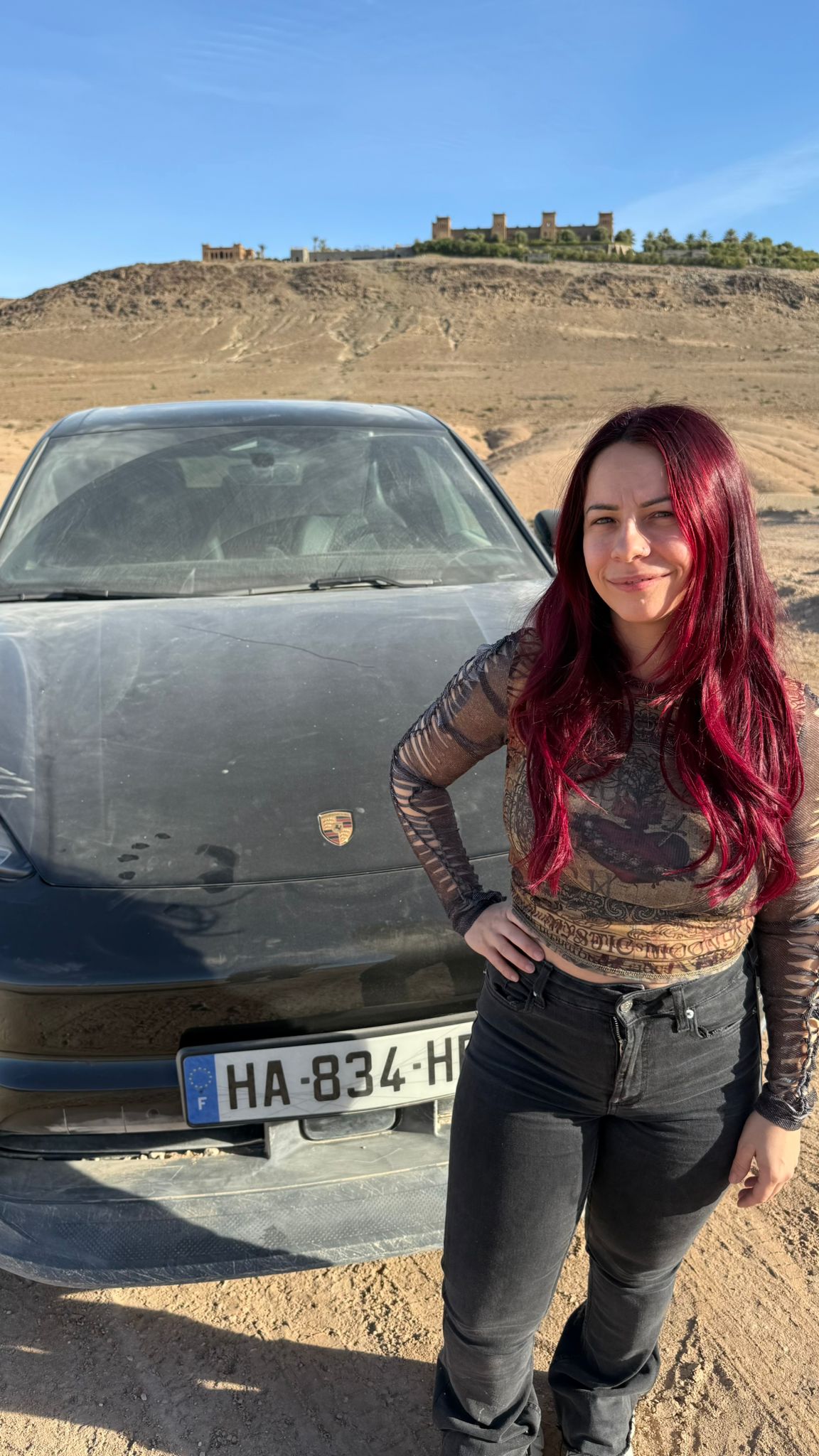 Adeline Chetail et le Porsche Macan Électrique dans le désert d’Agafay Adeline Chetail posant devant le Porsche Macan électrique dans le désert d’Agafay